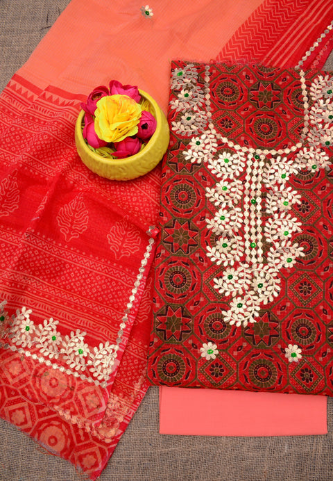 Flat lay of the unstitched Kota Doria Gota Patti suit set in red and peach with floral embroidery.