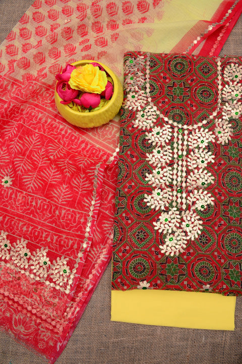 Flat lay of the unstitched Kota Doria Gota Patti suit set, featuring red and yellow fabric with floral embroidery