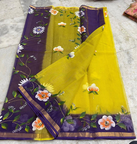 A Kota pure cotton saree with a hand-painted pattern in purple and yellow colors, including floral designs and a plain color blouse piece.