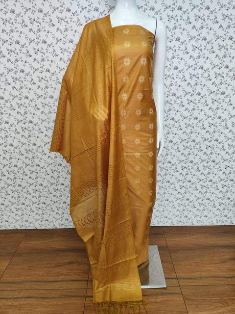 Golden mustard Semi Tussar Silk dress material with delicate woven motifs, matching dupatta, and plain bottom fabric. Perfect for festive occasions, weddings, and casual gatherings.
