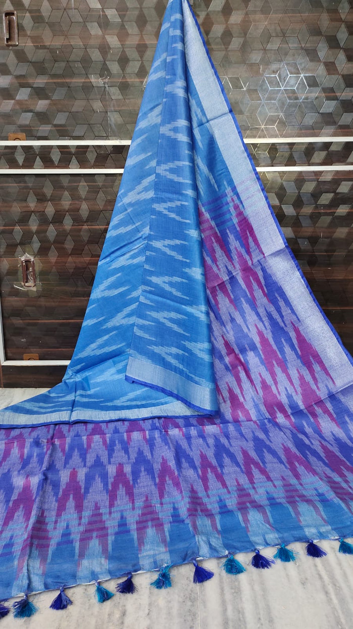 Blue and purple patterned fabric with tassels on a wooden background