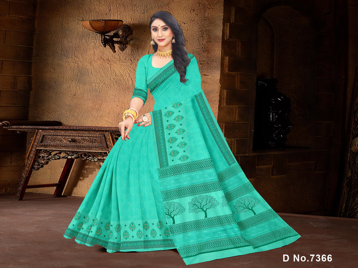 A woman showcasing a sea green pure cotton saree with embroidered and printed patterns.