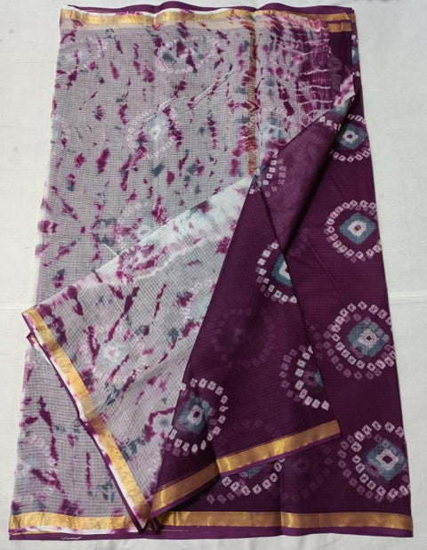 A purple tie-dye print pure cotton Kota saree with a geometric pattern and a golden border, displayed on a white background.