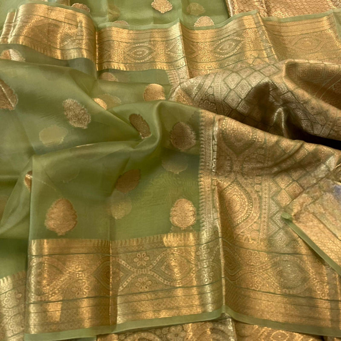 A green and gold Pure Organza Banarasi Silk Saree with a floral pattern and Zari woven design.