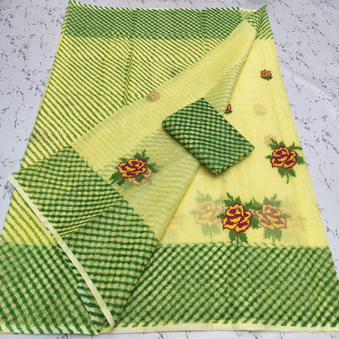 A green Kota Doria saree with embroidered floral patterns and a solid green border, displayed on a surface.
